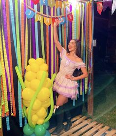 a woman standing next to a bunch of balloons