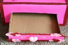 a pink box with hearts on it sitting on the floor