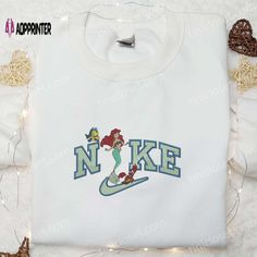 Nike x Ariel Embroidered Sweatshirt: Dive into the magical world of Disney with this enchanting sweatshirt. Featuring a beautifully detailed embroidery of Ariel, the little mermaid, this sweatshirt combines style and comfort effortlessly. Made with high-quality materials, it ensures durability and warmth. Whether you’re a Disney fan or a fashion enthusiast, this sweatshirt is a must-have addition to your wardrobe. Embrace your inner princess and make a bold statement with this Nike x Ariel Embroidered Apparel, World Of Disney, Disney Charms, Magical Kingdom, Adventure Style, Magical World, Embroidered Clothes, Embroidered Sweatshirt, Embroidered Hoodie