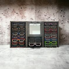 a pair of glasses sitting in front of a mirror on top of a counter next to a wall