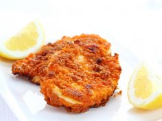 some food on a white plate with lemon slices