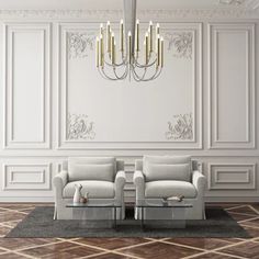 two gray couches sitting next to each other in front of a chandelier