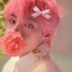 a person with pink hair and a flower in their mouth