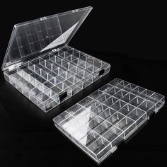 two clear plastic boxes with dividers on black background