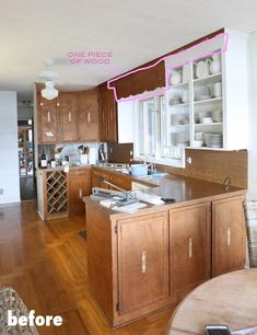 a kitchen with wooden floors and white walls has an island in front of the sink