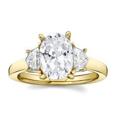 a three stone engagement ring with an oval cut diamond in the center and two pear shaped diamonds