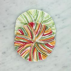 a multicolored dishcloth on a marble surface