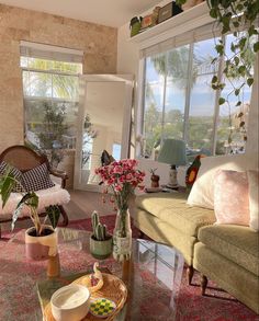 a living room filled with lots of furniture and flowers on top of a glass table