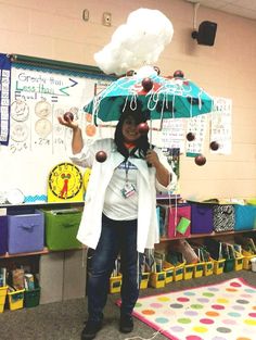 a woman holding an umbrella over her head while standing in front of a bulletin board