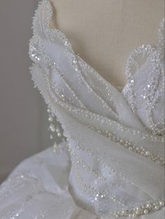 the back of a wedding dress with beading and pearls on it's skirt