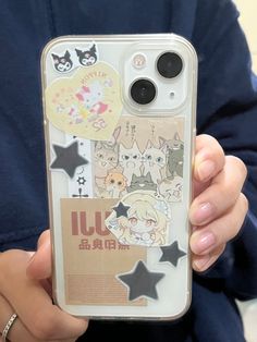 a person holding up an iphone case with stickers on it