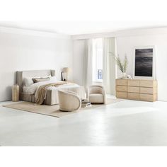 a bedroom with white walls and carpeted flooring is pictured in this image, there are two chairs on either side of the bed