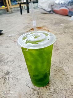 a green drink with a straw in it