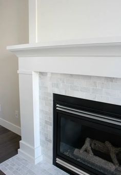 an empty living room with a fireplace and white painted brick surround the fire place in the house