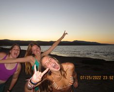 three girls posing for the camera with their hands in the air and one girl making peace sign