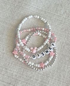 three bracelets with disney letters and pink stars are on the ground next to each other