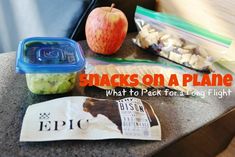 snacks on a table with an apple and some other food in plastic containers next to it