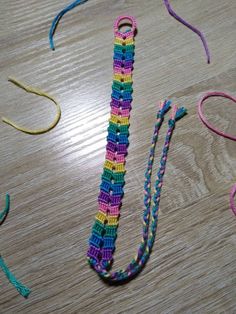 there is a crocheted tie on the table next to some scissors and thread