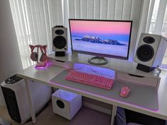 a desk with a computer and speakers on it