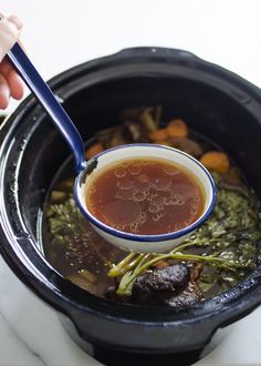 a spoon in a pot filled with soup and vegetables