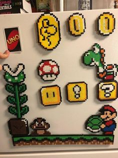 a refrigerator covered in magnets with mario and luigi on the front, along with other nintendo related items