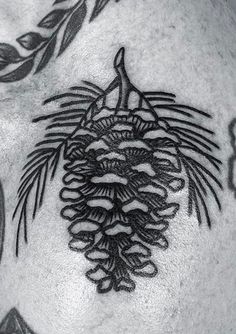 a man's chest has a pine cone tattoo on it, and is black and white