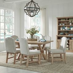 a dining room table with chairs and a chandelier