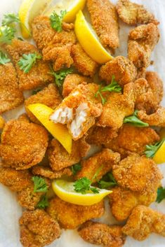 fried shrimp with lemons and parsley on a white paper towel, ready to be eaten