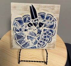 a blue and white plate sitting on top of a wooden table next to a pen