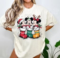 a woman wearing mickey and minnie mouse christmas t - shirt