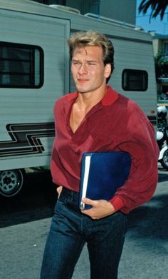 a man holding a binder in front of a motor home