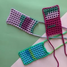 two crocheted hand warmers on top of a pink and green tablecloth