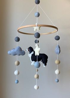 a mobile made out of felt balls with a black and white poodle on it