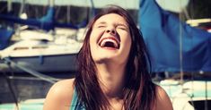 a woman laughing in front of some boats