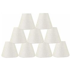 six white lampshades are arranged in a pyramid shape