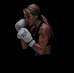 a woman in black shirt and white boxing gloves