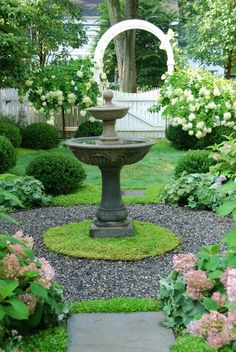 a small fountain in the middle of a garden