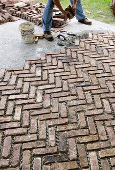 a man is laying bricks on the ground