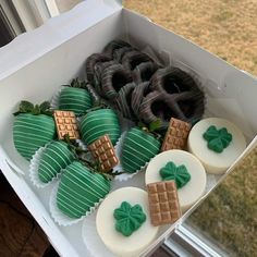 a box filled with lots of green and white desserts on top of a window sill