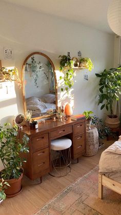 a bedroom with potted plants on the wall and a vanity in the corner, next to a bed