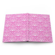 an open book with pink and white designs