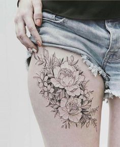 a woman's thigh with flowers and leaves on the bottom part of her thighs