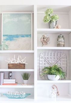 a white bookcase filled with lots of books and vases on top of it