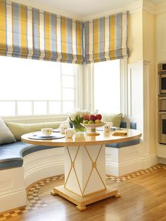 a kitchen with an oven, table and window seat in the corner next to it