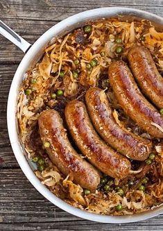 sausages and sauerkraut in a pan on a wooden table