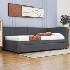 a bed sitting on top of a hard wood floor next to a book shelf and dresser