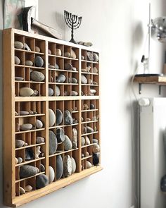 a wooden shelf filled with lots of rocks next to a menorah and chandelier