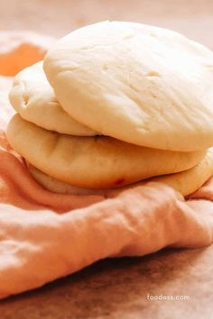 two cookies sitting on top of each other on a pink cloth next to an orange towel