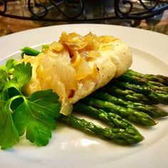 a white plate topped with asparagus and an entree on top of it