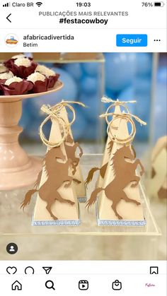 two brown and white horses on display in front of a vase with red rose petals